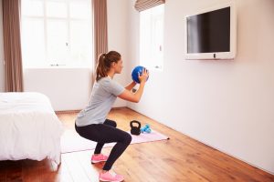 Woman squatting with ball