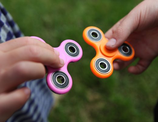 Two people holding fidget spinners